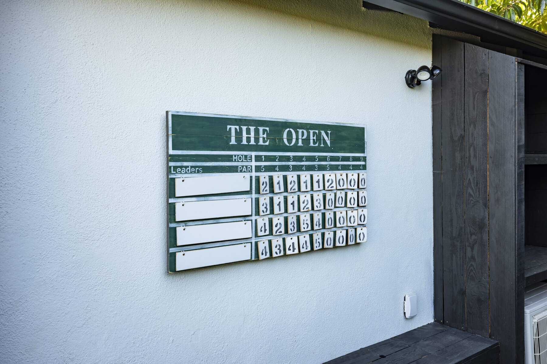 Golf leaderboard scoreboard for "The Open" mounted on exterior wall
