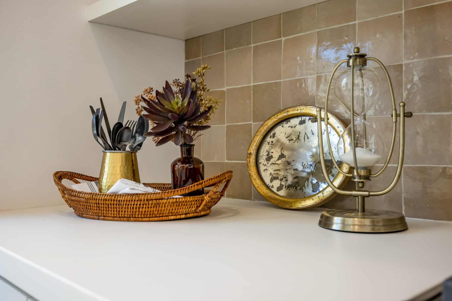 Countertop with a wicker tray, utensils, succulents, and decorative accents