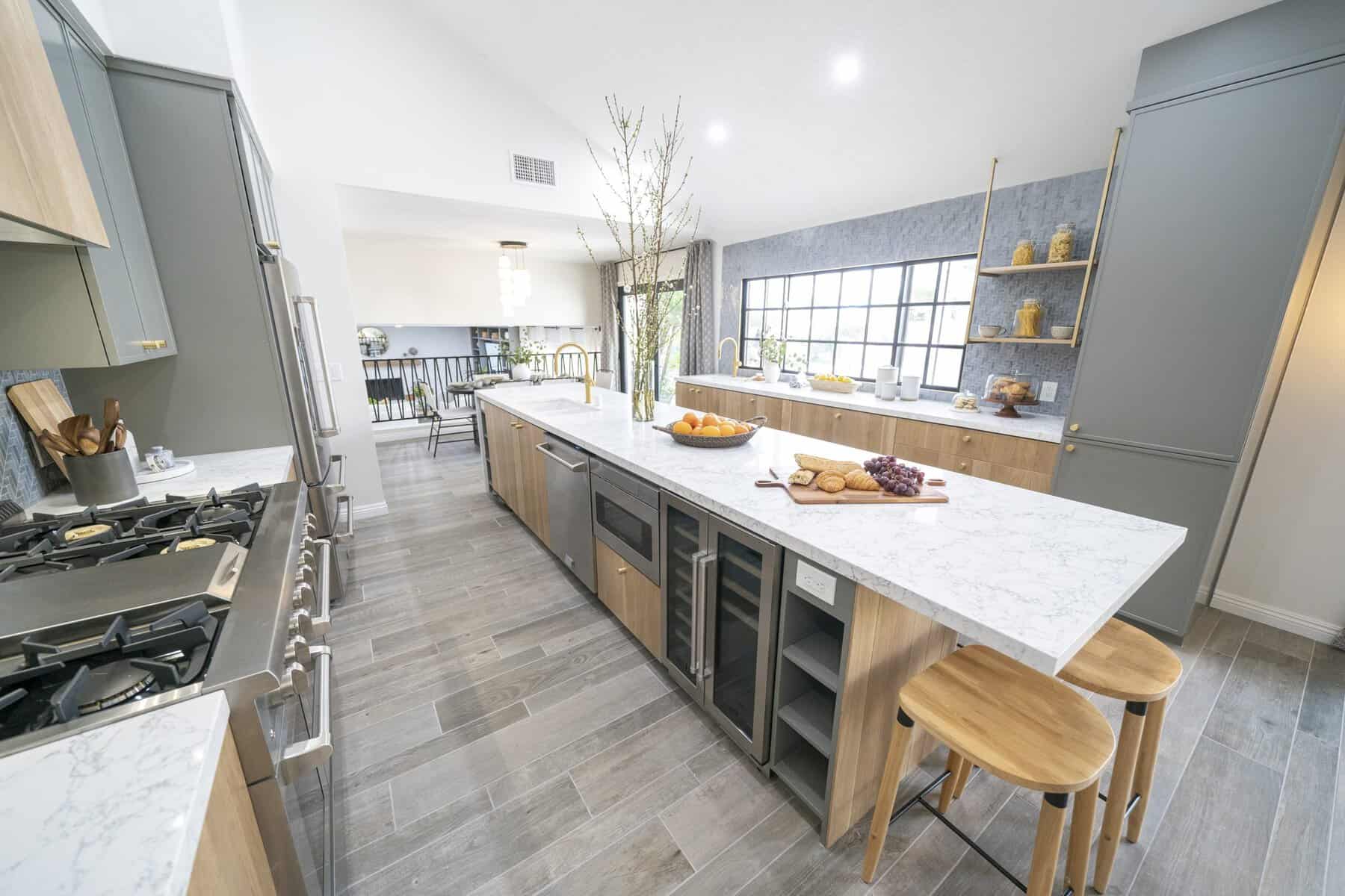 Modern kitchen with marble island, wood accents, and bar stools