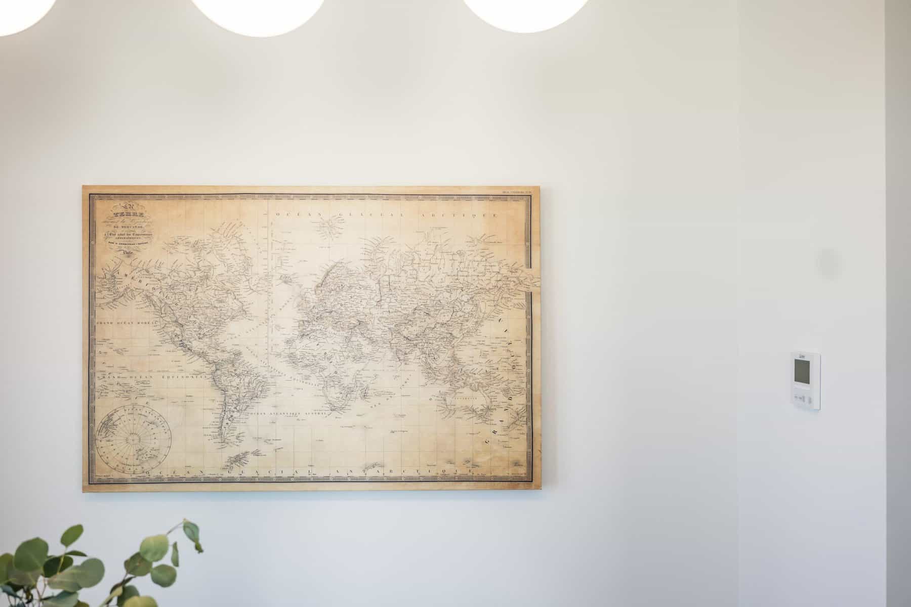 Framed vintage world map hanging on a white wall